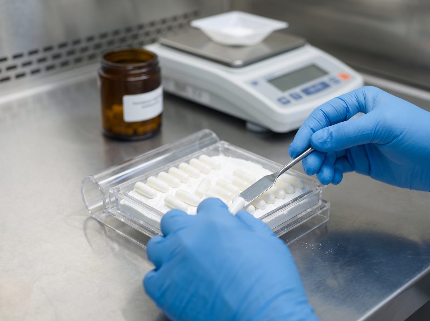 Illustrative: capsules being filled at a pharmacy bench