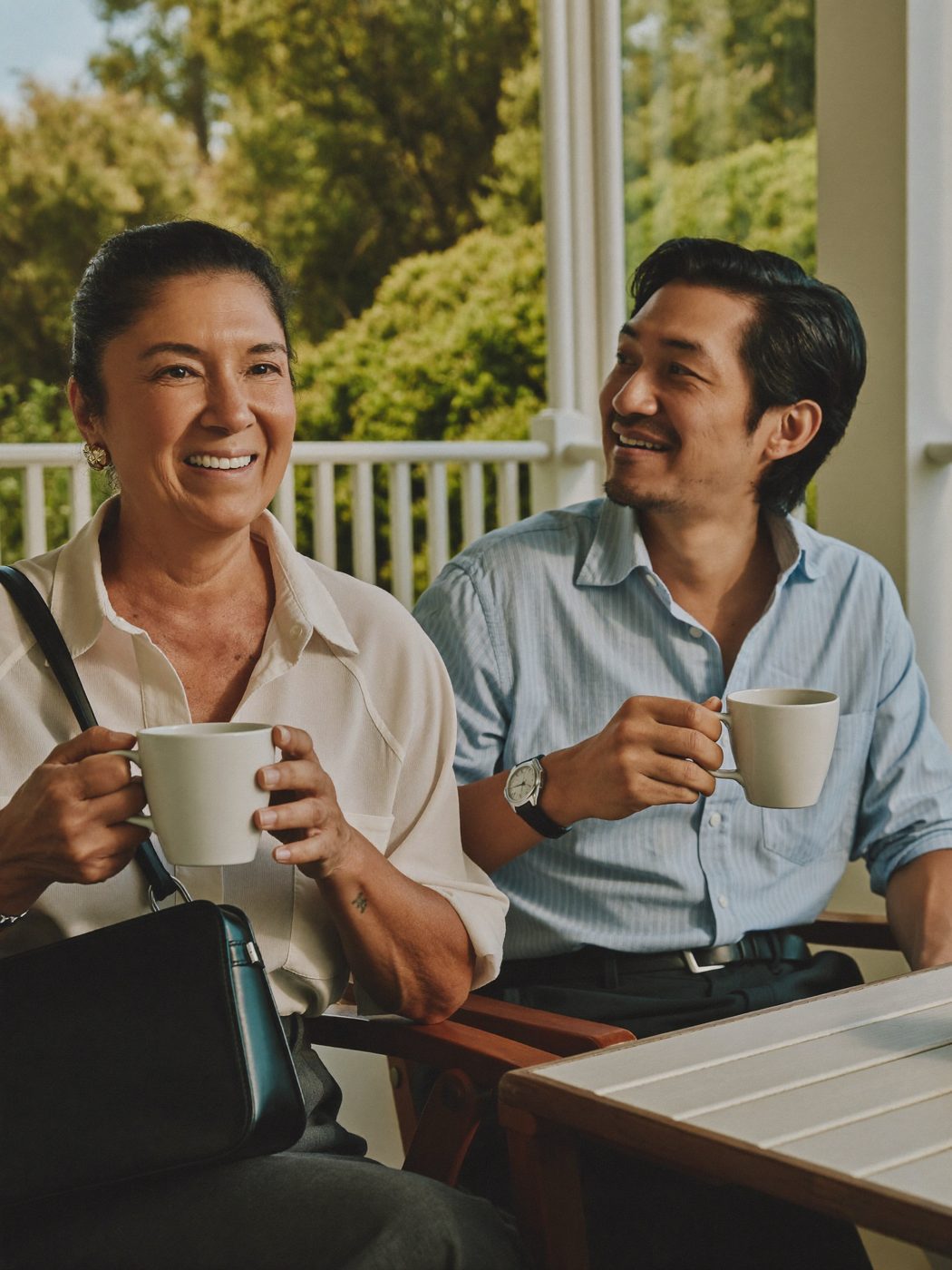 Illustrative: two adults over coffee on a porch